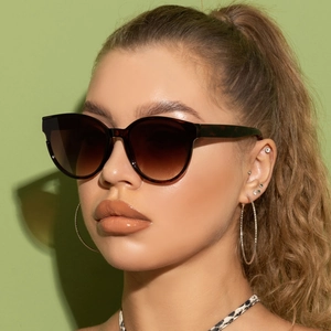 Side view of oversized tortoiseshell sunglasses with gradient brown lenses on female model