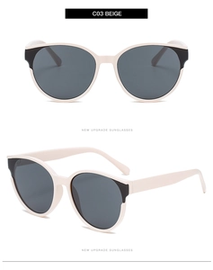 Detail view of beige oversized round sunglasses with dark grey lenses and black temple tips