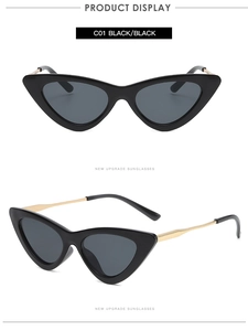 Close-up of vintage cat-eye sunglasses with black lenses and gold metal temples