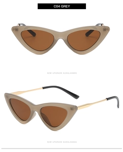 Detail view of grey cat-eye sunglasses with gold metal temples and brown lenses