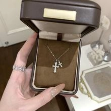Close-up of S925 sterling silver layered cross pendant necklaces and a diamond ring