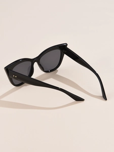 Detail of black cat-eye sunglasses with glossy finish and dual gold rivets on temples