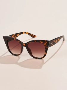 Detailed view of cat-eye sunglasses featuring tortoiseshell frame and gold dot accents
