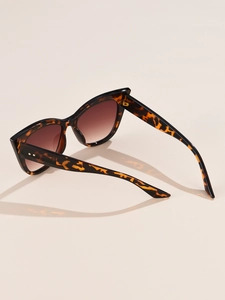 Detail of tortoise shell cat eye sunglasses with gold hinges and round metal rivets