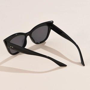 Stylish black cat eye sunglasses with gold dot accents shown from a side profile angle
