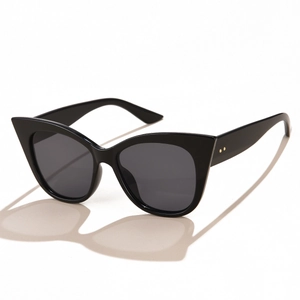 Retro black cat-eye sunglasses with wide frames and gold rivet details on white background