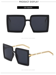 Détail macro de lunettes de soleil carrées avec monture noire et branches chaîne dorée