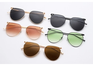 Flat lay of multiple stylish metal sunglasses with gradient and dark lenses in various colors