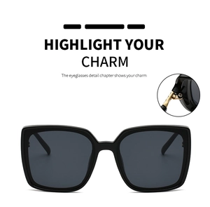 Close-up of golden metal hinge and sleek black square frame on modern sunglasses