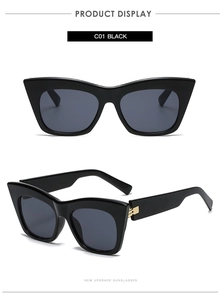 Detail view of black cat-eye sunglasses with luxury gold metal accents on the temples