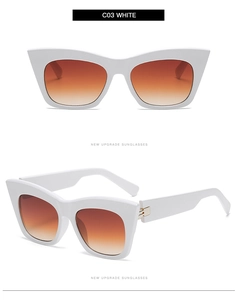 Detail view of white cat-eye sunglasses with gradient lenses and gold metal hinges