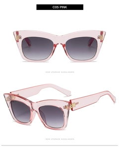 Detail of pink cat eye sunglasses with gold metal hinges and grey gradient lenses