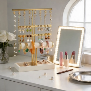 Golden jewelry tower with white velvet base showing necklace hooks and ring slots