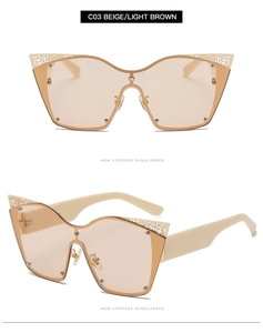 Detail of beige cat eye sunglasses featuring gold hollow carved metal decor on the frame