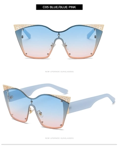 Detail of oversized cat-eye sunglasses with blue-pink gradient lenses and gold wire decor