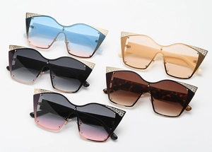 Flat lay of cat-eye sunglasses in five colors with metal cutouts and rivets