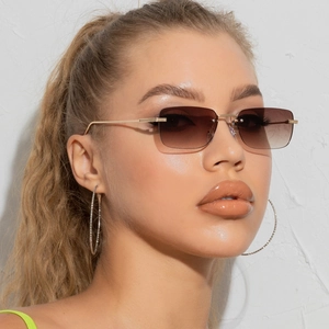 Detail of rimless square sunglasses featuring gradient brown lenses and gold metal temples