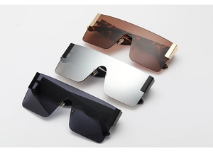 Detail view of large square oversized sunglasses in leopard and black frames with metal hinges