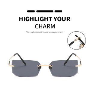 Detail of rimless square sunglasses with gold metal hinges and dark grey tinted lenses