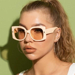 Retro oversized square sunglasses with beige frames and orange lenses on female model