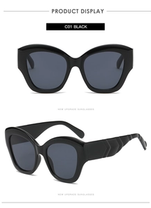 Detail of black cat eye sunglasses with wavy textured temples and dark grey lenses