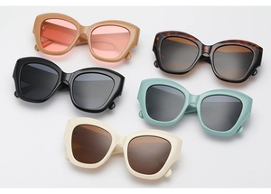 Flat lay of five fashion cat-eye sunglasses in various colors including tortoiseshell and beige