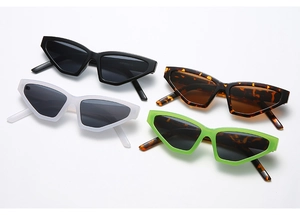 Flat lay of retro triangle cat eye sunglasses in black, white, tortoiseshell, and green