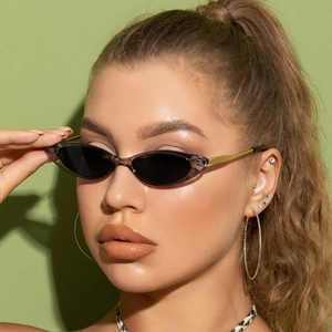 Close-up of retro cat-eye sunglasses with purple frames and golden metal temples on a model