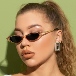 Close-up of retro narrow cat-eye sunglasses with amber frame and gold metal temples