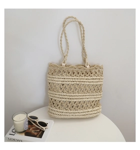 Detail of hollow-out crochet texture on a cream summer straw tote bag for beach vacations