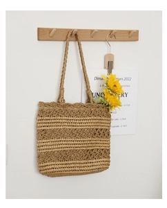 Detail of hollow hand-woven straw bag with geometric patterns for beach holidays