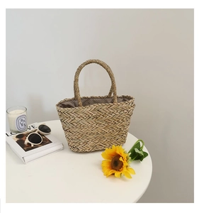 Détail d'un sac en paille tissé main avec doublure à pois et anses rondes