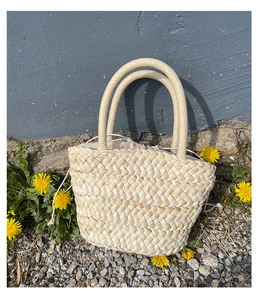 Detailed texture of handmade corn husk woven tote bag with beige drawstring lining