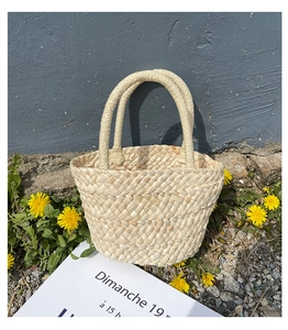 Close-up of handwoven corn husk tote bag with sturdy round handles and textured finish