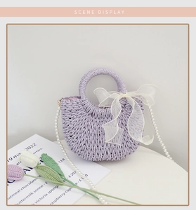 Detail of lavender woven bag with white bow and elegant faux pearl shoulder strap