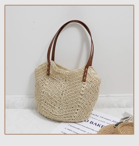 Gros plan sur la texture tissée ondulée et les poignées en cuir synthétique brun du sac
