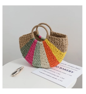 Close-up of the colorful rainbow straw weaving texture and round handles on a beach bag