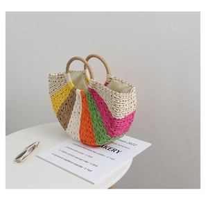 Detailed macro view of colorful rainbow woven straw bag with circular handles on table