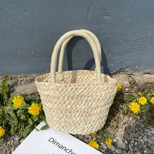 Handcrafted corn husk woven tote bag in natural cream color for summer beach style