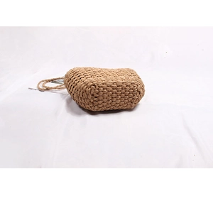 Detailed view of handmade woven straw bag featuring natural khaki texture and chic handles