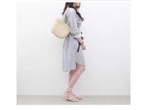 Minimalist straw shoulder bag paired with blue striped shirt dress and sandals