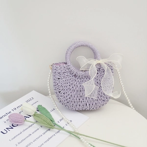 Handmade purple straw woven beach bag with translucent white bow and pearl shoulder strap