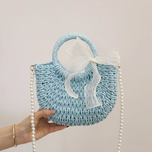 Light blue crescent straw bag with pearl strap and bow detail for summer beach vacations