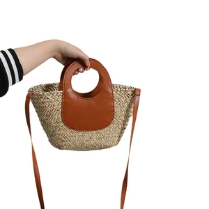 Handwoven seagrass crossbody bag with brown PU leather handles for summer beach vacations