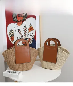 Detail of vintage straw tote bags with brown leather handles and white stitching details