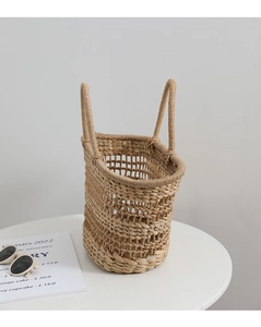 Macro view of French retro hollow woven straw bag with natural textured handles