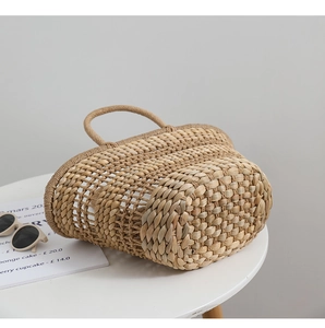 Detailed view of the natural straw woven handle and texture of this French basket bag