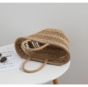 Detail of hand-woven straw tote bag with round handles and natural rustic texture