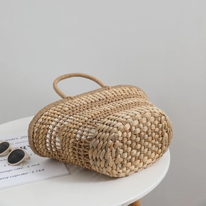 Handmade woven straw tote bag with natural texture and round handles for summer beach vacations