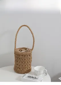 Détail d'un sac seau en paille ajouré avec doublure à cordon et poignée tressée